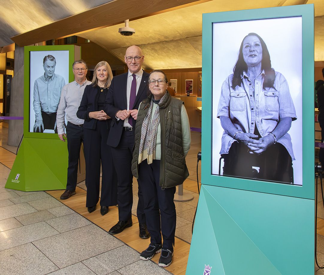 John Wright OBE, Presiding Officer Alison Johnstone, First Minister John Swinney and Jryna Batters pictured at a new Exhibition at the Scottish Parliament featuring victims of the infected blood scandal.