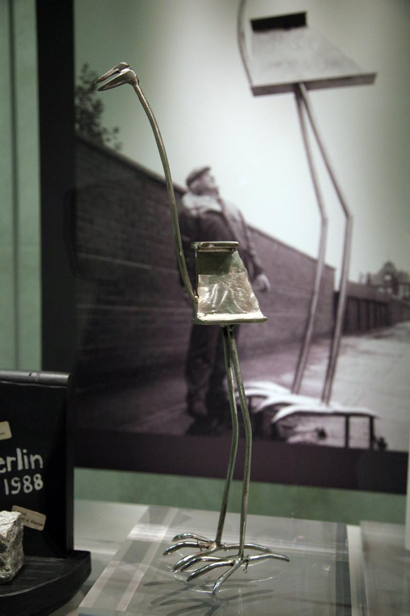 Small steel abstract sculpture in a display case of a bird
