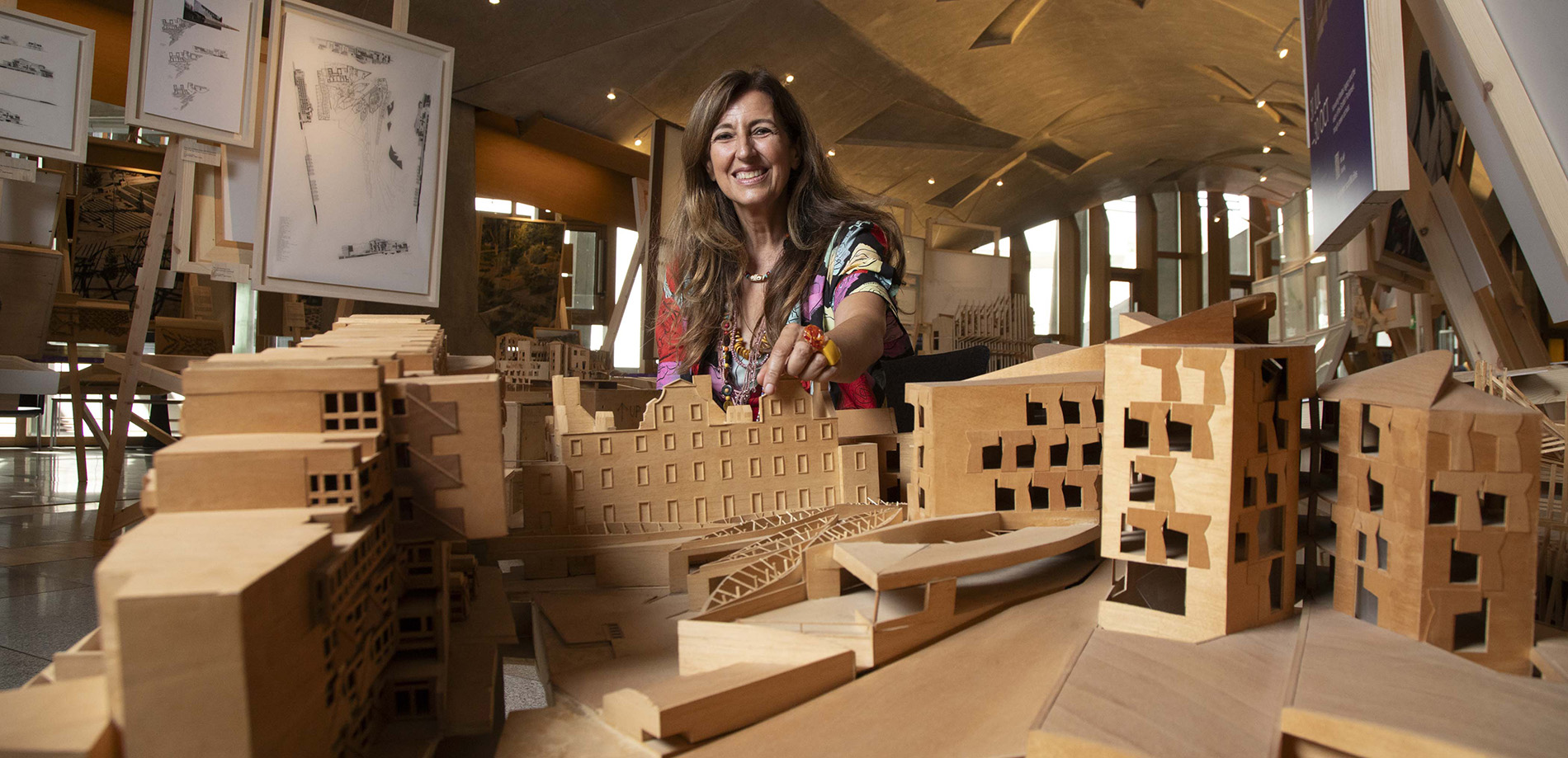 Architect Benedetta Tagliabue posing behind a model of the Scottish Parliament Building